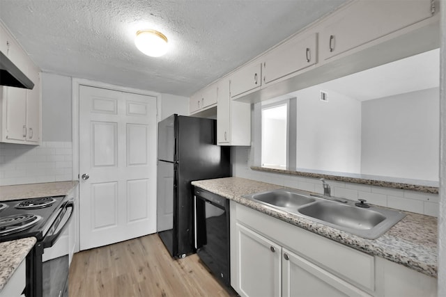 kitchen with sink, black appliances, white cabinets, decorative backsplash, and light wood-type flooring