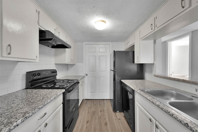 kitchen with white cabinetry, sink, decorative backsplash, black appliances, and light wood-type flooring