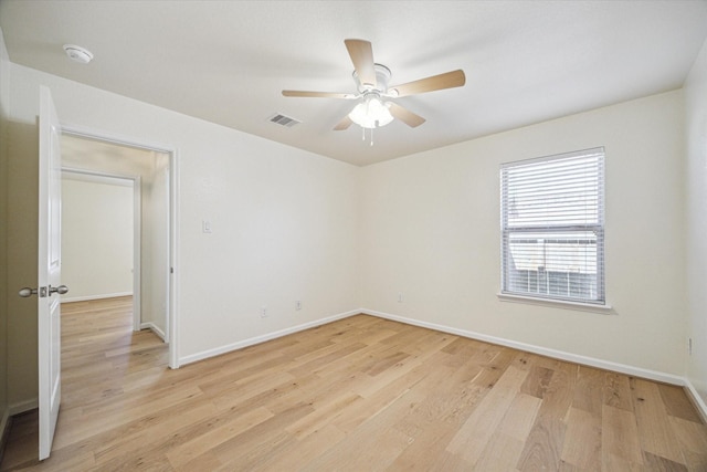 empty room with ceiling fan and light hardwood / wood-style flooring