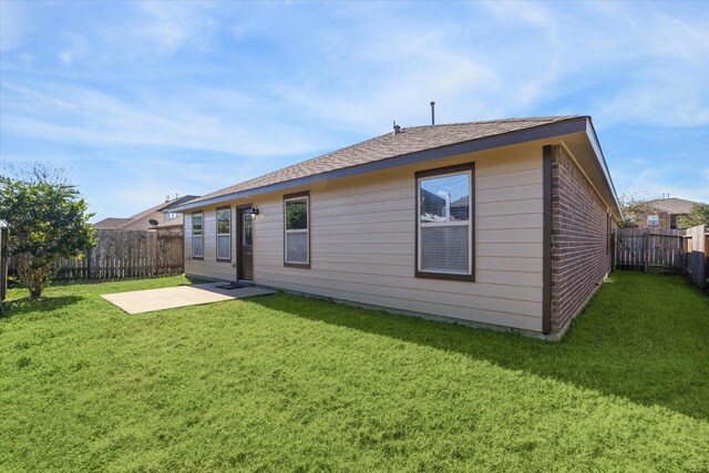 back of house with a lawn and a patio area