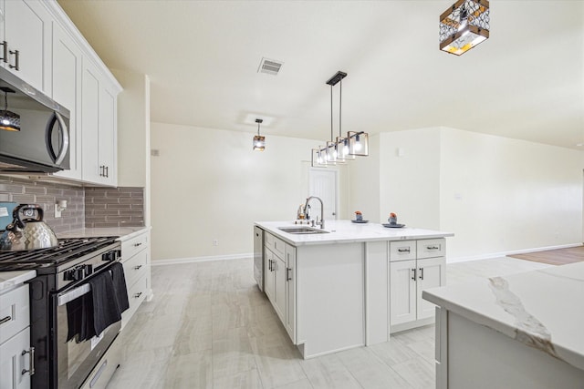 kitchen featuring white cabinetry, sink, an island with sink, and appliances with stainless steel finishes