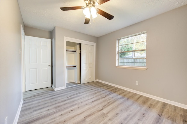 unfurnished bedroom featuring a textured ceiling, light hardwood / wood-style flooring, a closet, and ceiling fan