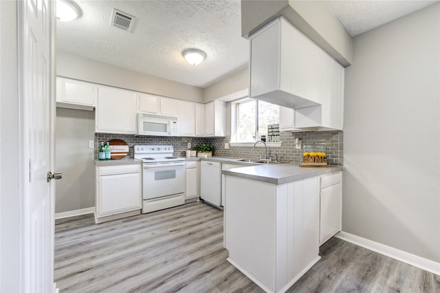 kitchen with white cabinetry, white appliances, sink, and a textured ceiling