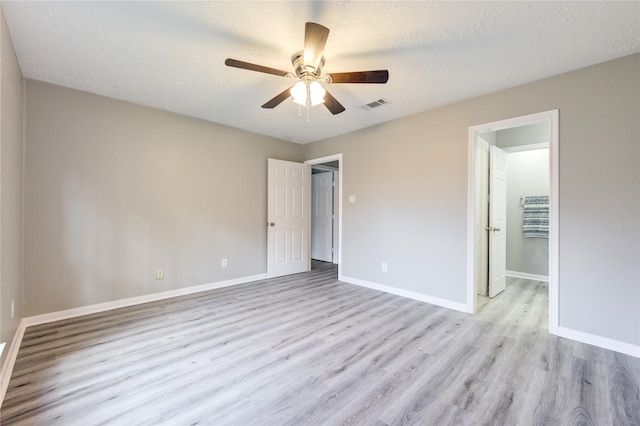 unfurnished bedroom featuring ceiling fan, a textured ceiling, and light wood-type flooring