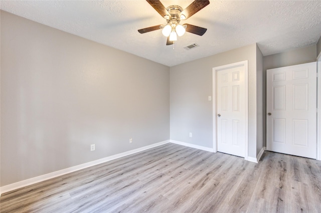 unfurnished bedroom featuring a textured ceiling, ceiling fan, and light hardwood / wood-style floors