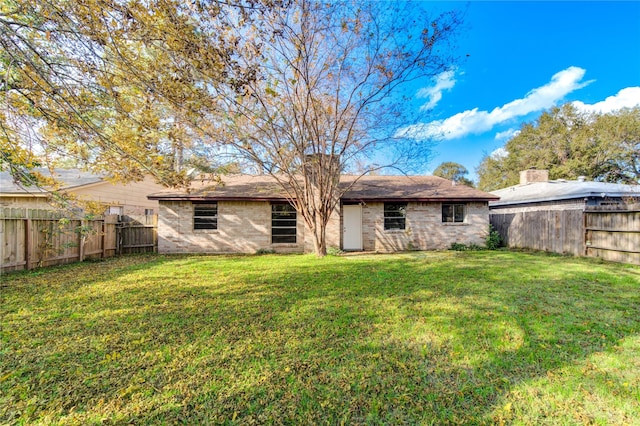 rear view of property with a lawn