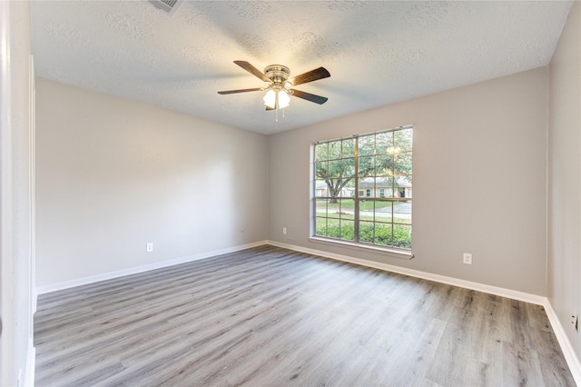 spare room with ceiling fan, a textured ceiling, and light hardwood / wood-style flooring