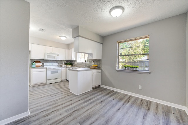 kitchen with white cabinetry, white appliances, light hardwood / wood-style flooring, and a textured ceiling