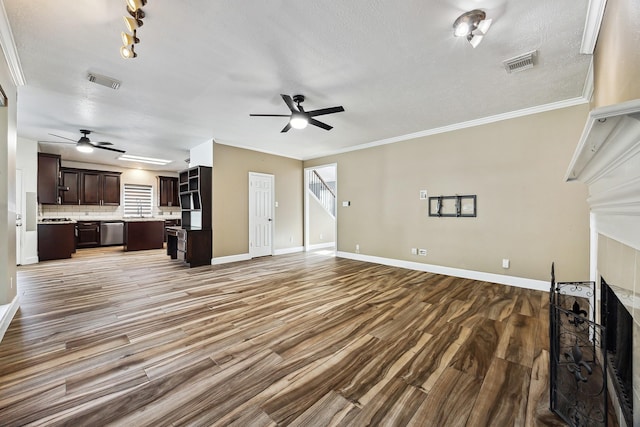 unfurnished living room featuring hardwood / wood-style floors, crown molding, a premium fireplace, and ceiling fan