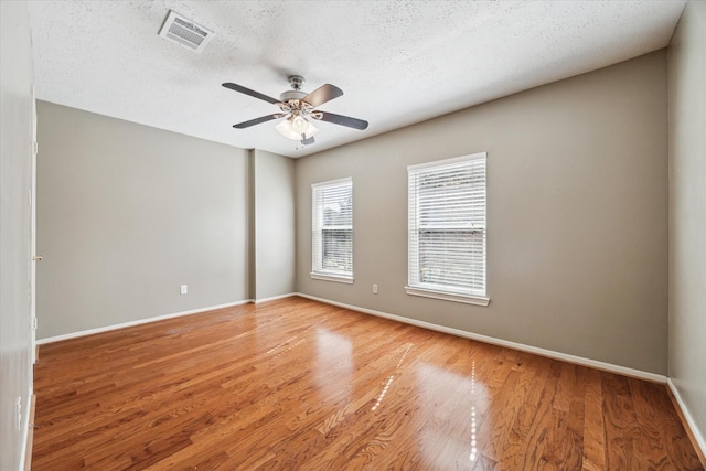 unfurnished room with ceiling fan, light hardwood / wood-style floors, and a textured ceiling