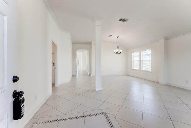 spare room featuring vaulted ceiling, light tile patterned floors, a notable chandelier, and crown molding