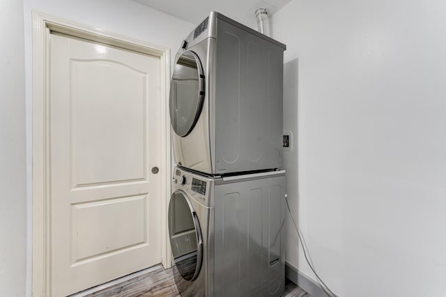 washroom featuring stacked washer and dryer and light hardwood / wood-style flooring