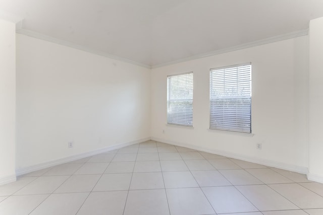 tiled spare room featuring crown molding