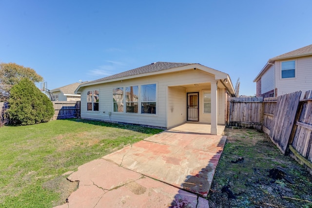 rear view of property featuring a lawn and a patio