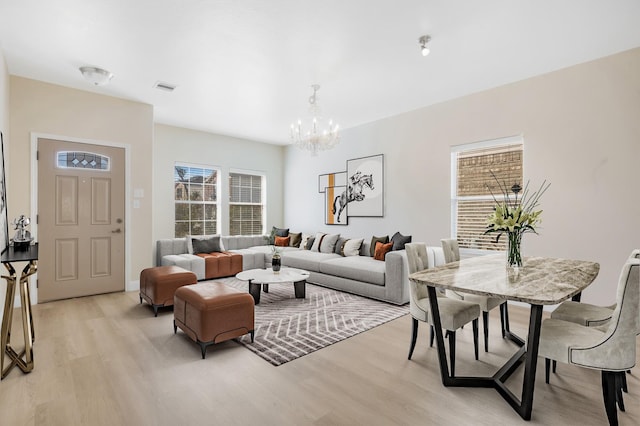 living room featuring a notable chandelier and light hardwood / wood-style floors