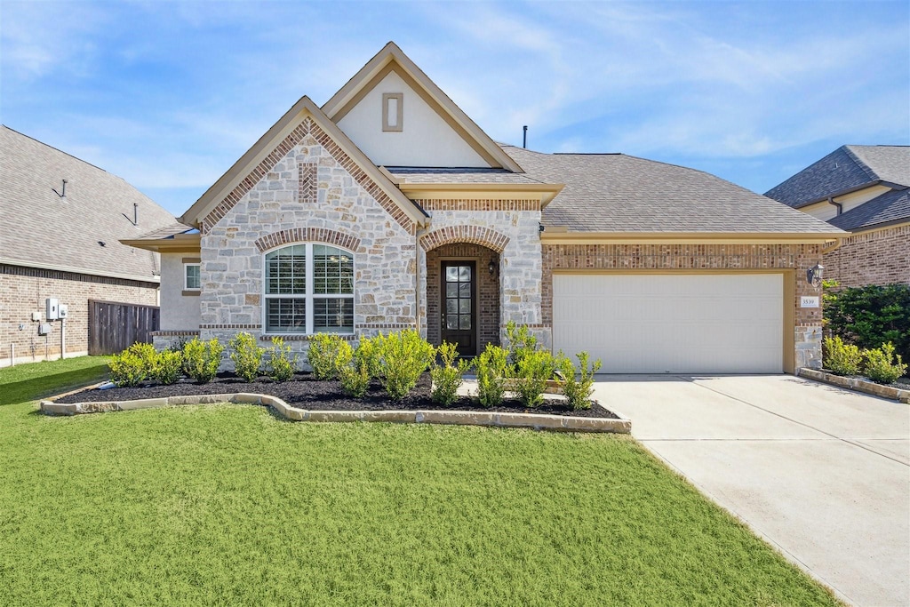 view of front of home with a garage and a front yard