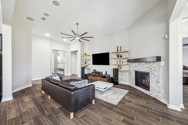 living room with ceiling fan and a fireplace