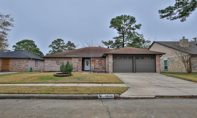 single story home featuring a garage and a front lawn