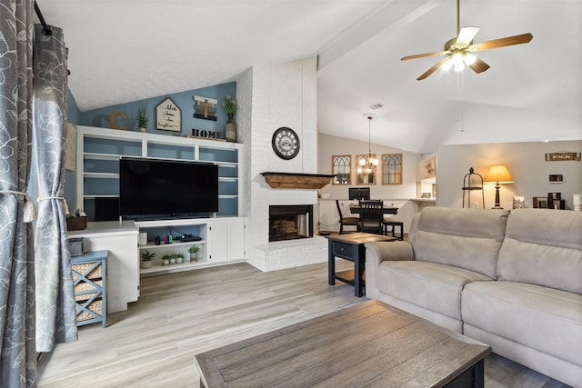 living room with lofted ceiling, a fireplace, light hardwood / wood-style floors, and ceiling fan