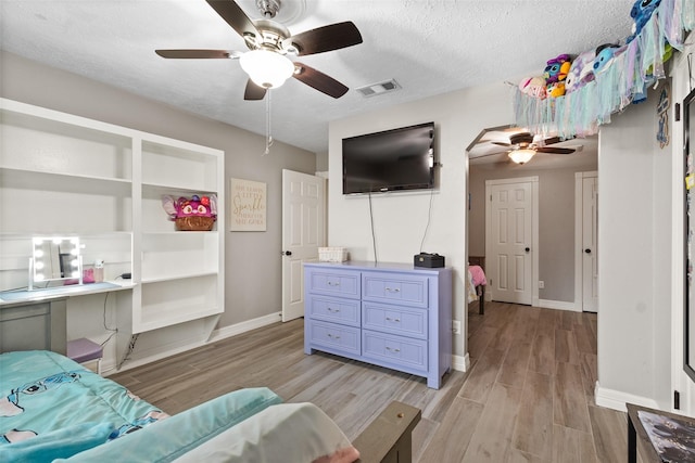 bedroom featuring a textured ceiling, ceiling fan, and light wood-type flooring