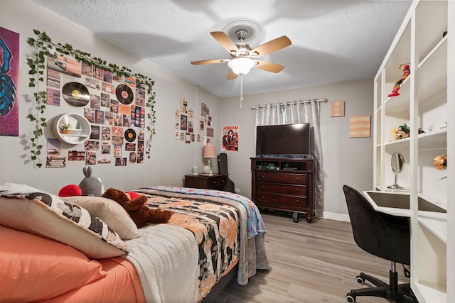 bedroom featuring a textured ceiling, ceiling fan, and light hardwood / wood-style floors