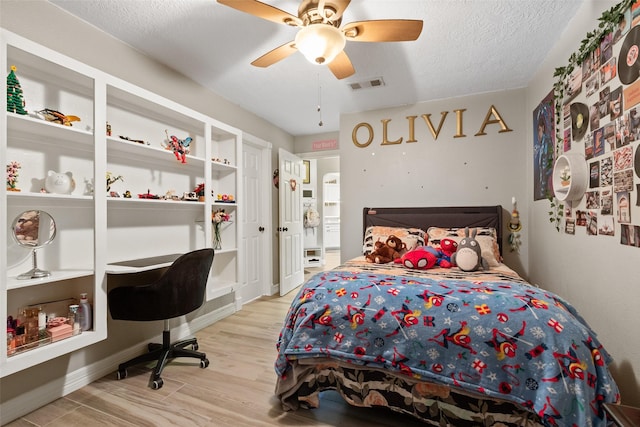 bedroom featuring a textured ceiling, light hardwood / wood-style flooring, and ceiling fan