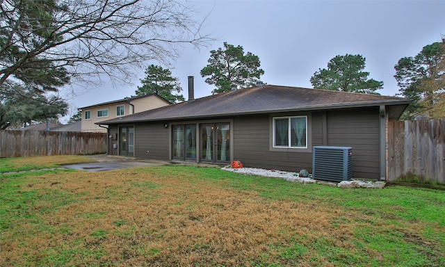 back of property featuring a yard, cooling unit, and a patio area