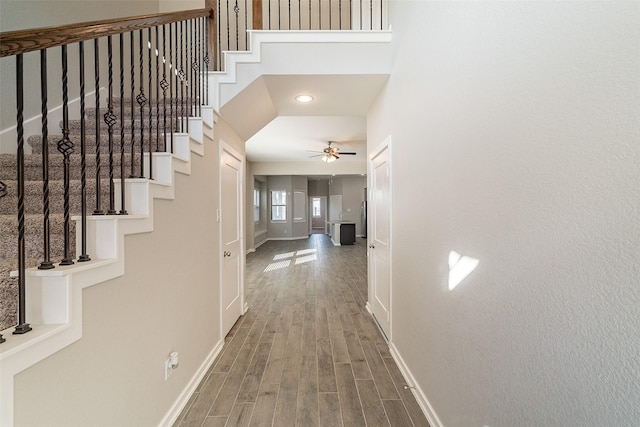 hallway featuring wood-type flooring and a high ceiling