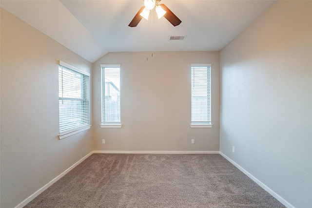 carpeted spare room with ceiling fan, lofted ceiling, and plenty of natural light