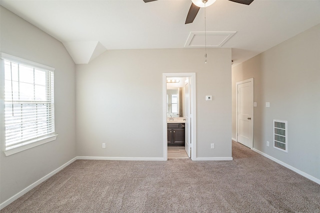 unfurnished bedroom with light carpet, connected bathroom, lofted ceiling, and ceiling fan