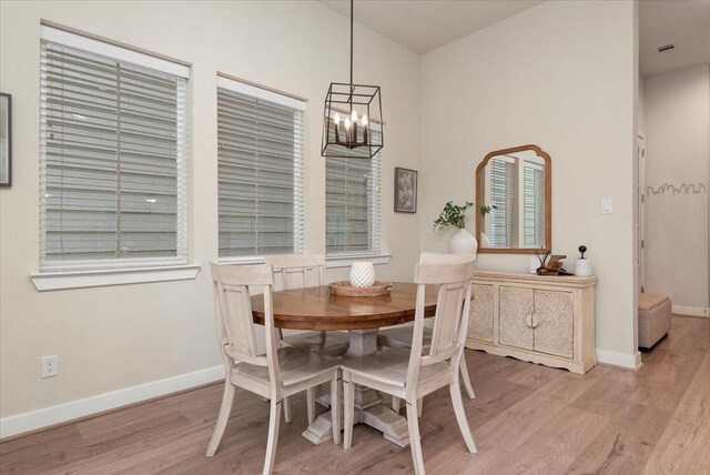 dining area with an inviting chandelier and light hardwood / wood-style floors