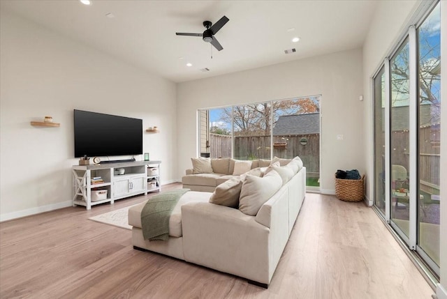 living room with a wealth of natural light, ceiling fan, and light hardwood / wood-style flooring