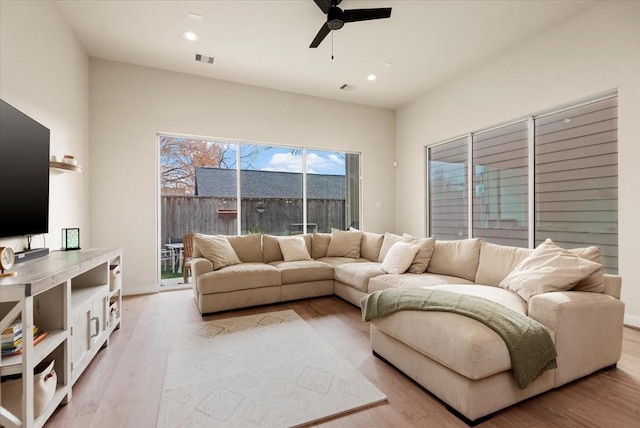 living room featuring ceiling fan and light hardwood / wood-style floors