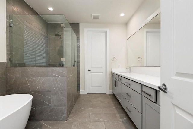 bathroom with vanity and independent shower and bath