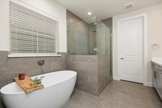 bathroom featuring vanity and shower with separate bathtub