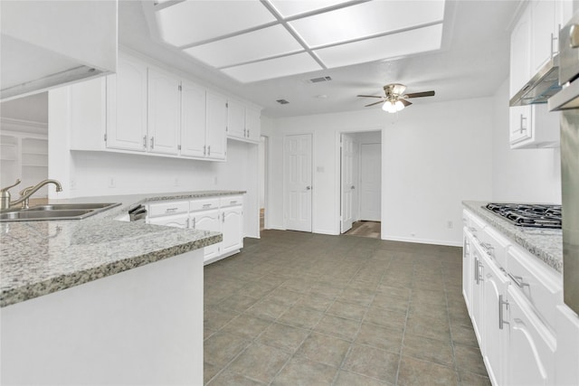 kitchen featuring sink, ceiling fan, light stone counters, stainless steel gas cooktop, and white cabinets