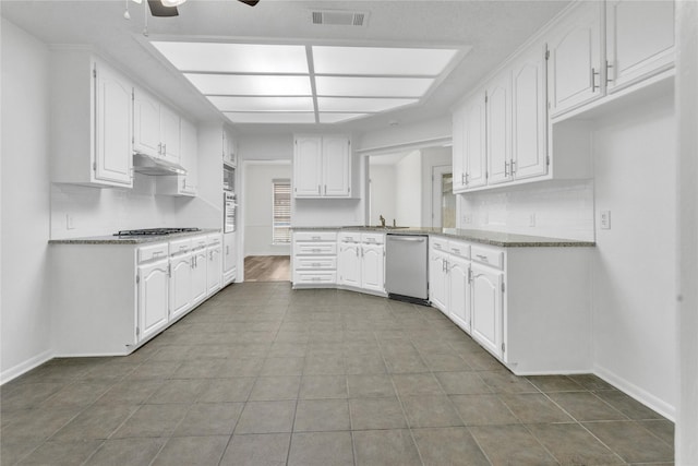 kitchen featuring stainless steel appliances, tasteful backsplash, white cabinets, and ceiling fan