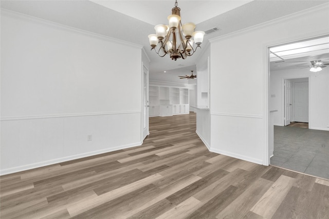 unfurnished dining area with crown molding, ceiling fan with notable chandelier, and wood-type flooring