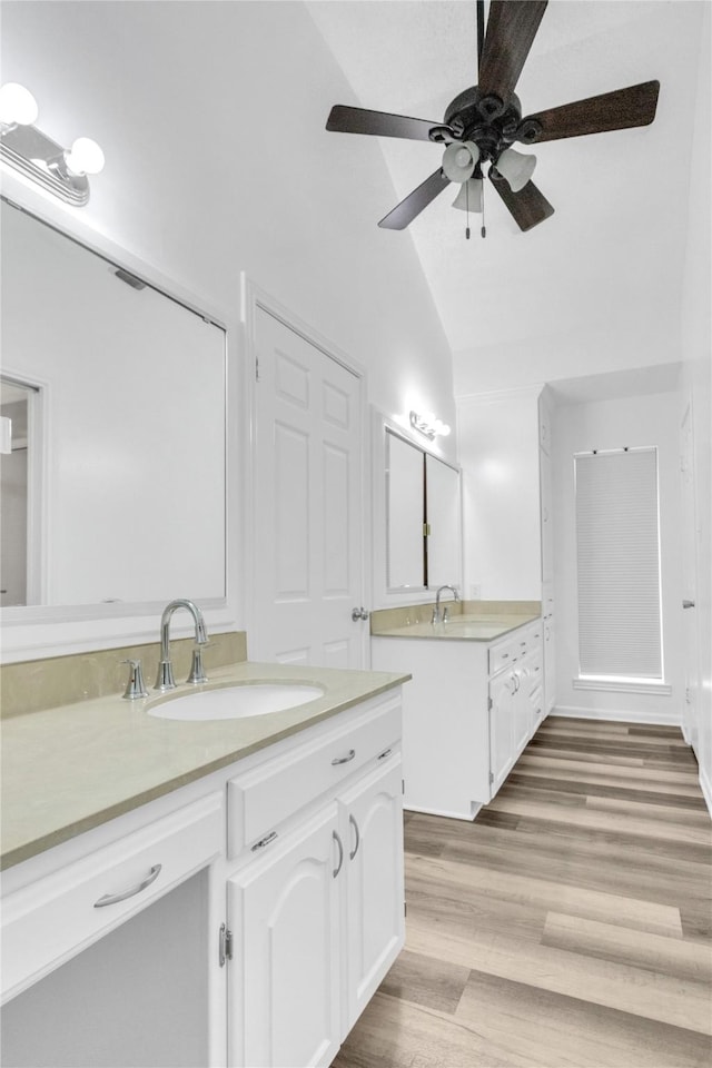 bathroom with vaulted ceiling, hardwood / wood-style floors, vanity, and ceiling fan