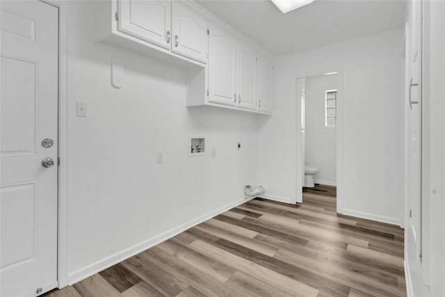 washroom featuring gas dryer hookup, cabinets, washer hookup, electric dryer hookup, and light wood-type flooring