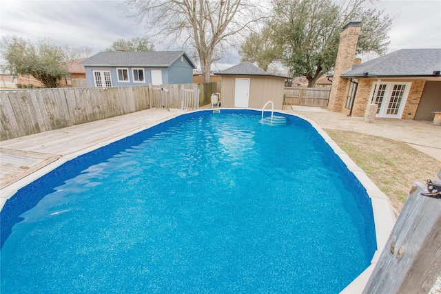 view of pool featuring an outbuilding, a patio area, and french doors