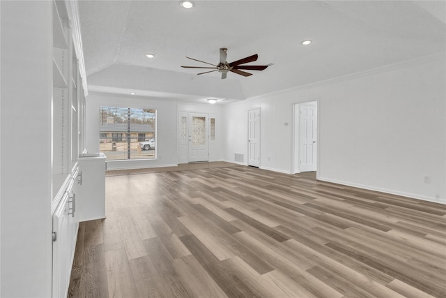 unfurnished living room featuring light hardwood / wood-style flooring, ceiling fan, ornamental molding, a textured ceiling, and a raised ceiling