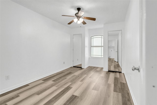 unfurnished bedroom with ceiling fan and light hardwood / wood-style floors