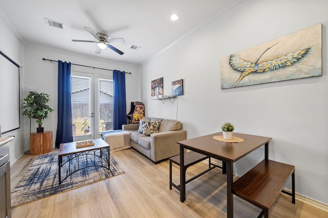 living room featuring crown molding, ceiling fan, and light hardwood / wood-style floors