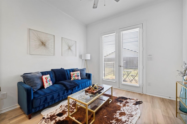 living room with hardwood / wood-style floors, crown molding, and ceiling fan