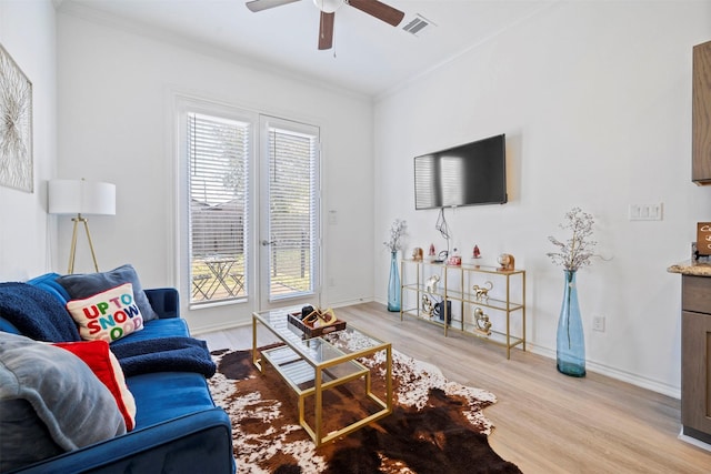 living room with crown molding, ceiling fan, and light hardwood / wood-style flooring