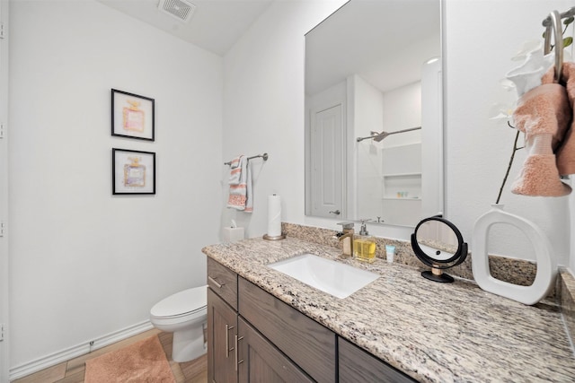 bathroom with vanity, toilet, and a shower