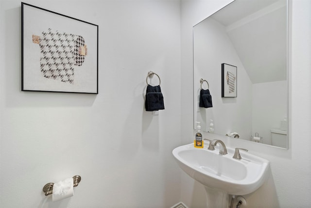 bathroom featuring lofted ceiling and sink