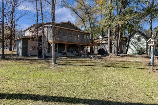 rear view of property featuring a wooden deck, a lawn, and a sunroom