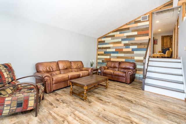 living room featuring light hardwood / wood-style floors and vaulted ceiling